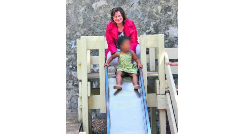 Esther Alder, conseillère administrative, joue avec un enfant sur un tobbogan du parc des Bastions; un jeu bientôt changé. 
