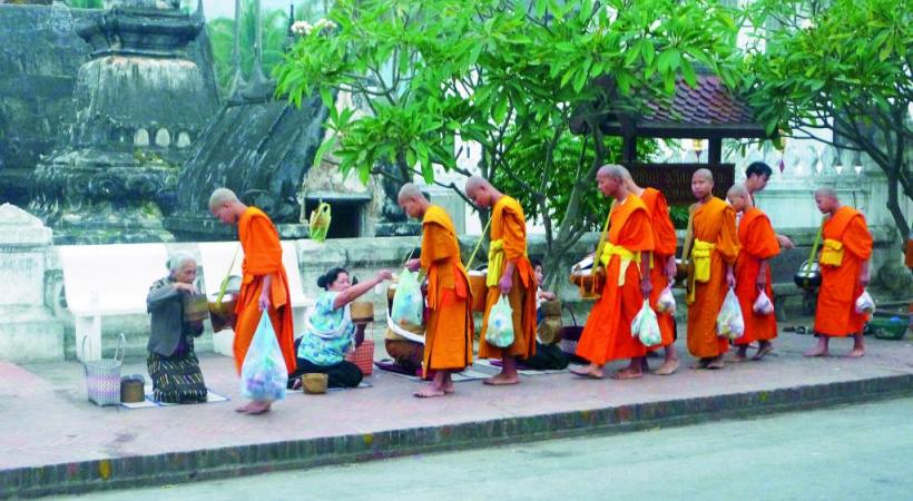 Au petit matin, les offrandes des fidèles  aux moines dans la rue principale. 